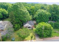 Aerial view of a charming two-story home with a front porch nestled among lush greenery and mature trees at 338 Candler Rd, Atlanta, GA 30317