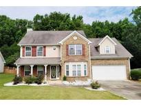 Charming two-story home featuring a manicured lawn, brick accents, and attached two car garage at 2086 Grant Ave, Mcdonough, GA 30252