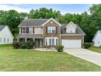 Charming two-story home with a well-manicured lawn and a two-car garage at 2086 Grant Ave, Mcdonough, GA 30252