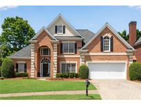 Beautiful brick home featuring manicured lawn and a two-car garage, with black shutters and mature landscaping at 4769 Ellington Ct, Marietta, GA 30067