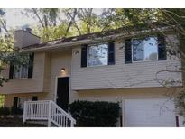 Attractive split-level home featuring neutral siding, black shutters, and a one-car garage at 5295 Old Trail Cir, Stone Mountain, GA 30088