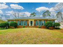 Charming brick home featuring blue shutters and manicured landscaping at 118 Heritage Way, Peachtree City, GA 30269