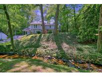 Charming two-story home featuring a stone facade, red door, and lush greenery at 2162 Brookview Nw Dr, Atlanta, GA 30318