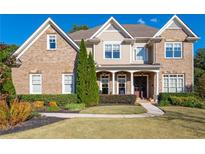 Beautiful brick two-story home with a well-manicured lawn and covered front porch at 440 Scott Farm Dr, Powder Springs, GA 30127