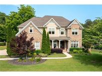 Charming brick home with a well-manicured lawn and inviting front porch at 440 Scott Farm Dr, Powder Springs, GA 30127