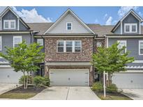 Charming townhome featuring a brick facade, two-car garage, and beautifully landscaped front yard at 2543 Oakbourne Ln # 14, Smyrna, GA 30080