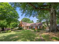 Charming brick home with a well-manicured lawn, mature trees, and an inviting front entrance at 503 Bonnie Dr, Woodstock, GA 30188