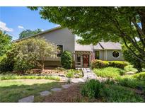 Charming home featuring lush landscaping, inviting walkway, and a welcoming entrance with pergola at 635 Stone Harbor Sw Pkwy, Marietta, GA 30060