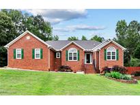 Charming single-story brick home with well-manicured lawn, green shutters, and a welcoming entrance at 124 Crown Walk, Mcdonough, GA 30253