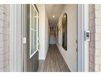 Inviting foyer featuring light wood floors, a staircase, and modern decorative mirror at 209 Maycrest Path, Tucker, GA 30084