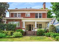 Charming two-story brick home featuring a welcoming front porch and well-manicured landscaping at 1095 Saint Charles Ne Pl, Atlanta, GA 30306