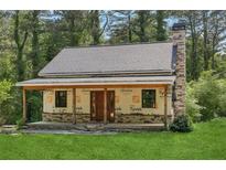 Charming home featuring a stone chimney, covered porch, and lush green lawn at 2003 Greeson Rd, Dacula, GA 30019