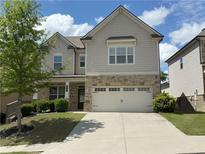 Charming two-story home with stone accents, well-manicured lawn, and a spacious two-car garage at 2320 Ivy Birch Ln, Buford, GA 30519