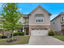 Beautiful two-story home with a stone and shingle exterior, lush landscaping, and a two-car garage at 2320 Ivy Birch Ln, Buford, GA 30519
