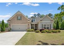Charming home with a well-maintained lawn, a two-car garage, and a mix of brick and siding exterior at 3219 Blackshear Dr, Marietta, GA 30060