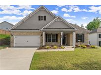 Charming single-Gathering home featuring a brick facade, well-manicured lawn, and inviting curb appeal under a sunny sky at 7995 Brewton Creek Dr, Cumming, GA 30028