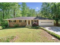 Charming one-story brick home with a well-manicured lawn and mature trees, creating a welcoming curb appeal at 1131 Mayfield Dr, Decatur, GA 30033