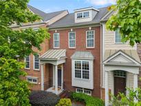 Charming townhome with brick facade, covered porch, and manicured landscaping, creating an inviting curb appeal at 4879 Seldon Se Way, Smyrna, GA 30080