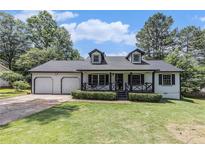 Charming home with a well-manicured lawn, two-car garage, dormer windows and inviting front porch at 5406 Jamestowne Dr, Powder Springs, GA 30127