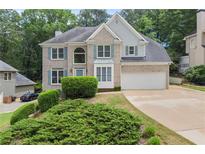 Charming two-story brick home with a well-manicured lawn and an attached two-car garage at 8032 Ridge Vly, Woodstock, GA 30189