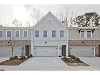 Modern townhome with a brick and siding exterior and an attached garage and concrete driveway at 4527 Moray Dr, Mableton, GA 30126