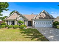 Charming single-story home with well-manicured lawn and lush landscaping under a clear blue sky at 3134 Milloak Ct, Buford, GA 30519