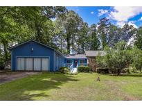 Charming single-story home with a large front yard and an attached two-car garage at 3739 Lake Carlton Rd, Loganville, GA 30052