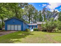 Charming blue home featuring a well-manicured lawn and an inviting entrance walkway at 3739 Lake Carlton Rd, Loganville, GA 30052