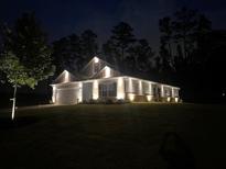 Charming single-story home featuring stylish exterior lighting and well-manicured lawn at nighttime at 426 Samara Ct, Fairburn, GA 30213