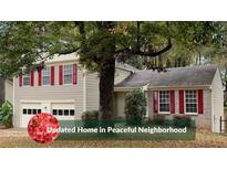 Charming two-story home featuring a well-maintained lawn, an attached two-car garage, and red shutters at 615 Barrington Way, Roswell, GA 30076