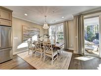Elegant dining room featuring stylish chairs, chandelier, modern art, and a sliding glass door to outdoor living area at 2270 Siskin Square Rd # 91, Duluth, GA 30096