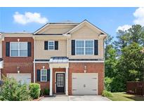 Charming townhouse with brick and beige siding, complemented by black shutters and a single car garage at 2755 Greenbridge Dr, Norcross, GA 30071