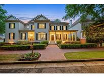 Charming two-story home with a brick walkway, manicured landscaping and a welcoming covered front porch at 8109 Lawnview, Alpharetta, GA 30022