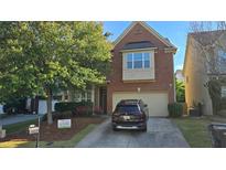 Charming brick two-story home with a two-car garage, a well-maintained lawn, and a driveway for extra parking at 2275 Copper Trail Ln, Buford, GA 30519