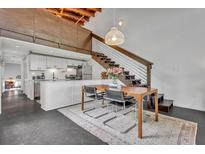 Bright dining area featuring a modern table with chairs, a stairway, and an adjacent sleek white kitchen at 510 Edgewood Ne Ave # 6, Atlanta, GA 30312