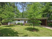 Charming single-story home with mature trees, lush lawn, and a covered parking area at 3018 Monterey Dr, Decatur, GA 30032