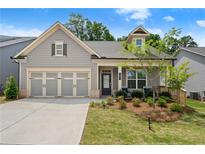 Charming single-story home featuring a well-manicured lawn and a welcoming front porch at 207 Hickory Bluffs Pkwy, Canton, GA 30114
