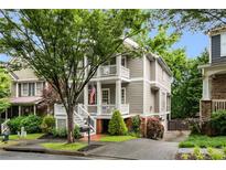 Charming two-story home featuring a welcoming front porch, mature tree, and lovely landscaping at 1626 Gilstrap Nw Ln, Atlanta, GA 30318