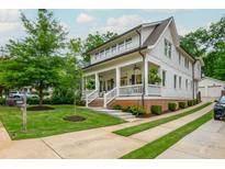 Beautiful two-story home featuring a welcoming front porch, pristine landscaping, and a private driveway leading to a detached garage at 172 Olympic Pl, Decatur, GA 30030