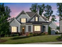 Charming two-story home with gray siding, brick accents, and manicured lawn set against a twilight sky at 2208 Sage Mountain Sw Ct, Marietta, GA 30064