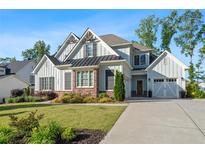 Charming two-story home featuring light blue siding, brick accents, and a well-manicured lawn at 2208 Sage Mountain Sw Ct, Marietta, GA 30064