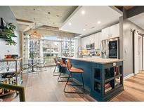 A kitchen with blue cabinets and a large island with seating for three, accented by a large window and modern appliances at 890 Memorial Se Dr # 102, Atlanta, GA 30316