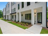 New townhouse exterior with white painted brick, black window trim, and manicured lawn at 2200 Carlton Ct # 6, Atlanta, GA 30318