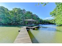 A private dock on the lake with a covered area provides direct water access and recreational opportunities at 975 Timber Lake Trl, Cumming, GA 30041