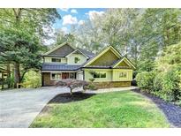 Charming home with beautiful landscaping, stone accents, and a lush, tree-filled yard at 975 Timber Lake Trl, Cumming, GA 30041