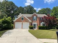 Charming two-story red brick home with a well-manicured lawn and a two-car garage at 3118 Stanstead Ct, Norcross, GA 30071
