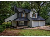 Charming two-story home featuring a two-car garage, attractive landscaping and a inviting front entry at 1930 Rocky Mill Ln, Lawrenceville, GA 30044