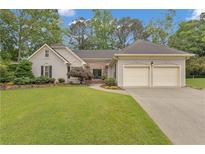 Charming home featuring a well-manicured lawn and a two-car garage, enhancing its curb appeal at 1152 Ward Creek Sw Dr, Marietta, GA 30064
