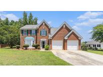 Charming two-story brick home with manicured lawn and attached two-car garage at 48 Savanna Ct, Powder Springs, GA 30127
