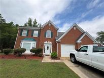 Charming two-story brick home features a well-manicured lawn and a two-car garage at 48 Savanna Ct, Powder Springs, GA 30127